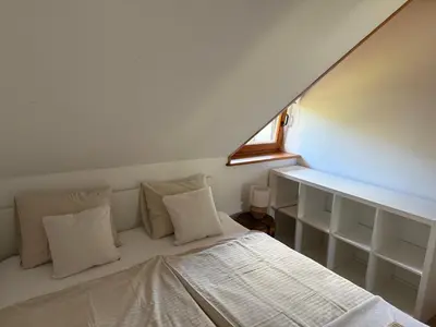 a bed with white pillows and a window in a room at Studio Lilly in Bohinj