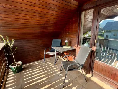 a patio with a table and chairs on a balcony at Studio Lilly in Bohinj