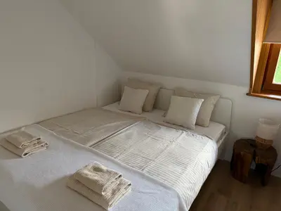 a white bed with towels on it in a room at Studio Lilly in Bohinj