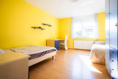 a bedroom with yellow walls and a bed and a desk at The Color Loft in Ljubljana