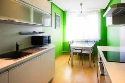 a kitchen with green walls and a table with a sink at The Color Loft in Ljubljana