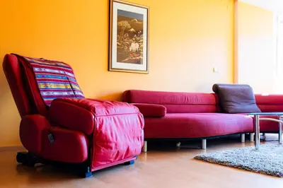 a living room with a red couch and a chair at The Color Loft in Ljubljana