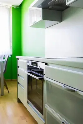a kitchen with a stove and a green wall at The Color Loft in Ljubljana