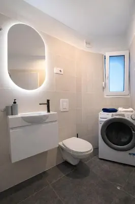 a bathroom with a toilet sink and a washing machine at LJ Apartments - Šempeter pri Gorici in Šempeter pri Gorici