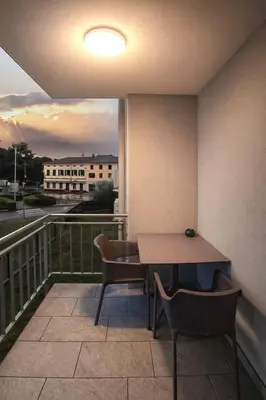 a table and chairs on a balcony with a view at LJ Apartments - Šempeter pri Gorici in Šempeter pri Gorici