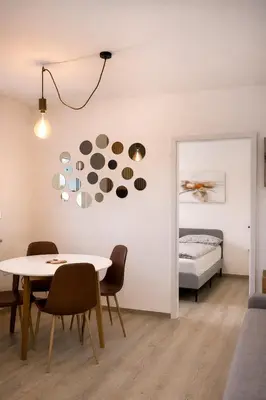a room with a table and chairs and a bed at LJ Apartments - Šempeter pri Gorici in Šempeter pri Gorici