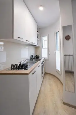 a white kitchen with a sink and a stove at LJ Apartments - Šempeter pri Gorici in Šempeter pri Gorici