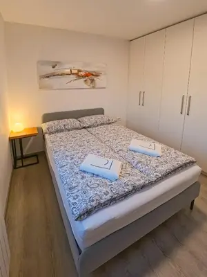 a bedroom with a bed with two folders on it at LJ Apartments - Šempeter pri Gorici in Šempeter pri Gorici