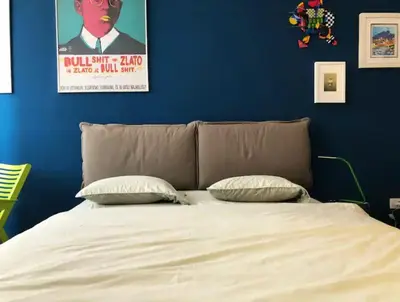 a bedroom with a bed with a blue wall at Rosa & Nora Apartments in Ljubljana