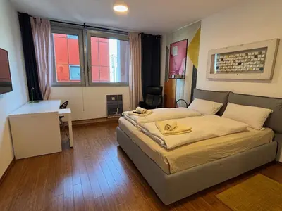 a bedroom with a bed and a desk in it at Rosa & Nora Apartments in Ljubljana