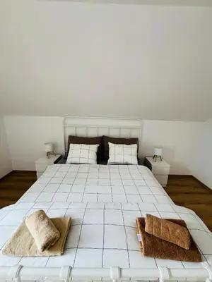 a bedroom with a large white bed with two pillows at Apartma DUDI