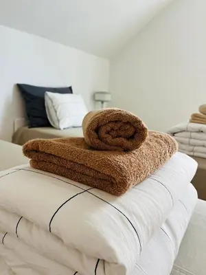 a pile of towels sitting on top of a bed at Apartma DUDI