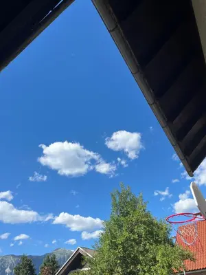 a basketball hoop with a blue sky and clouds at Apartma DUDI
