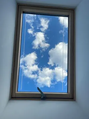 a window with a clock looking at the sky at Apartma DUDI