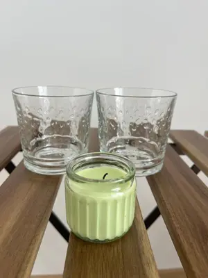 two glasses and a candle on a wooden table at Apartma DUDI