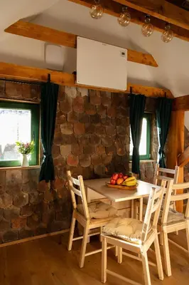 a kitchen with a table and chairs and a stone wall at Golavškov mlin - Eco Heritage Boutique Stay in Prebold