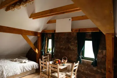 a bedroom with a bed and a table and chairs at Golavškov mlin - Eco Heritage Boutique Stay in Prebold