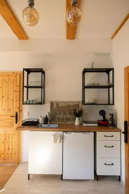 a kitchen with white cabinets and two mirrors at Golavškov mlin - Eco Heritage Boutique Stay in Prebold