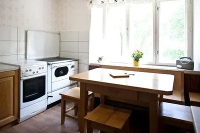 a kitchen with a table and a white stove at Počitniška hiša pod RAJHOVKO in Ljubno