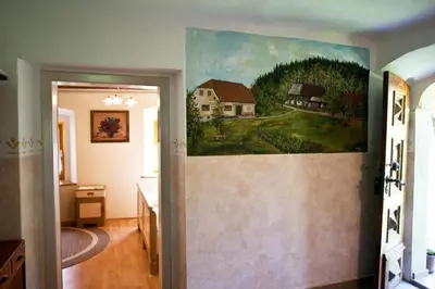 a painting of a farm on the wall of a room at Počitniška hiša pod RAJHOVKO in Ljubno