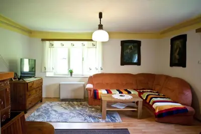 a living room with a couch and a table at Počitniška hiša pod RAJHOVKO in Ljubno
