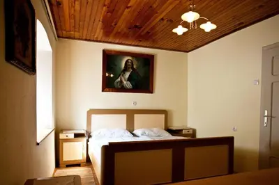 a bedroom with a bed with a painting on the wall at Počitniška hiša pod RAJHOVKO in Ljubno