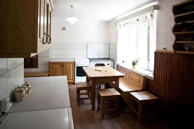 a kitchen with a wooden table and a dining room at Počitniška hiša pod RAJHOVKO in Ljubno