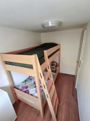 a small room with a bunk bed and a ladder at Hiša Terra in Volzana