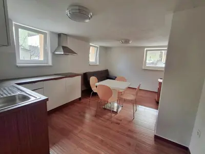 a kitchen with a table and chairs in a room at Hiša Terra in Volzana