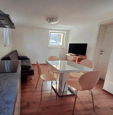 a living room with a white table and chairs at Hiša Terra in Volzana
