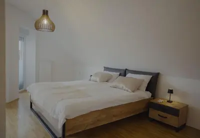 a bedroom with a large bed with white sheets at Rezidenca Vista Lux in Ptuj