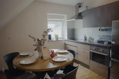 a kitchen with a wooden table with plates on it at Rezidenca Vista Lux in Ptuj