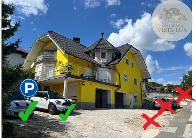 a yellow house with a car in front of it at Rezidenca Vista Lux in Ptuj
