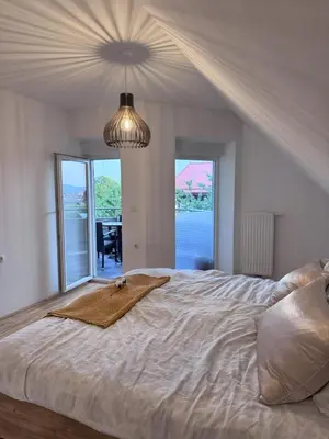 a bedroom with a large bed with a blanket on it at Rezidenca Vista Lux in Ptuj