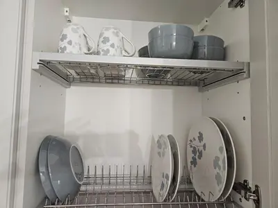 three plates and bowls on a shelf in a kitchen at Apartma VINT in Ajdovščina