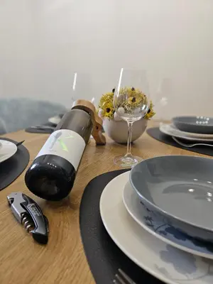 a bottle of wine and a glass on a table at Apartma VINT in Ajdovščina
