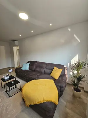 a living room with a brown couch with a yellow blanket at Apartma VINT in Ajdovščina