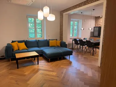 a living room with a blue couch and a dining room at Enchanting appartment Eipprova in Ljubljana