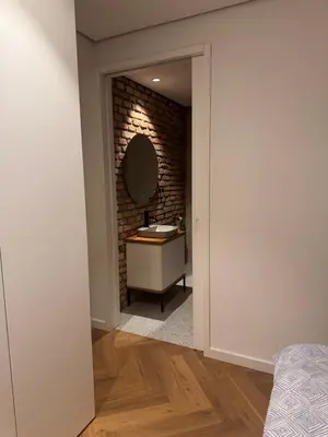 a bathroom with a sink and a brick wall at Enchanting appartment Eipprova in Ljubljana