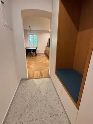 a hallway leading to a room with a table and a kitchen at Enchanting appartment Eipprova in Ljubljana