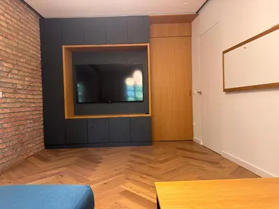 a living room with a tv and a brick wall at Enchanting appartment Eipprova in Ljubljana