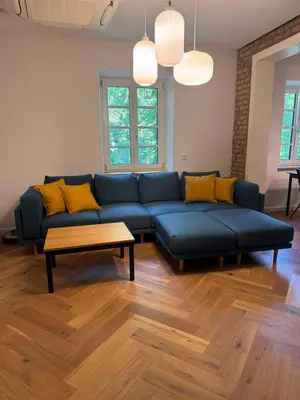 a living room with a blue couch and a table at Enchanting appartment Eipprova in Ljubljana