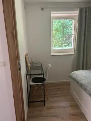 a bedroom with a table and a chair and a window at Natura in Radovljica
