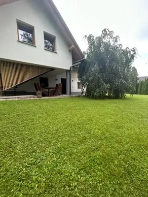 a house with a large yard with a green lawn at Natura in Radovljica