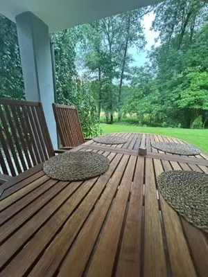 two chairs on a wooden deck with trees in the background at Natura in Radovljica