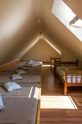 a attic with four beds in a room at Turistična Kmetija Toman in Gornji Grad