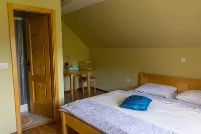 a bedroom with a bed with a blue pillow on it at Turistična Kmetija Toman in Gornji Grad