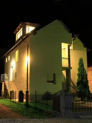 a house with a light on the side of it at night at Apartment with balcony Hiša Brdo 48 in Bovec