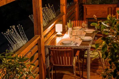 a wooden table with plates and glasses on a patio at Herbal Apartment Marjetka in Šentjur