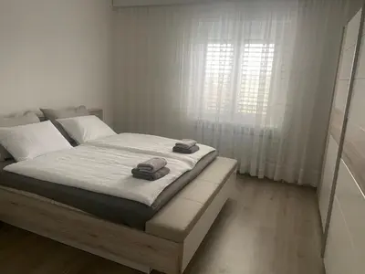 a white bedroom with a bed with towels on it at Hiša Tavčar in Dutovlje
